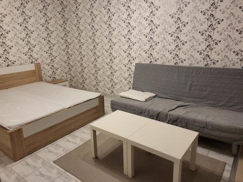 a room with a bed and a couch and a table at Zwaan Apartmány in Dunajská Streda