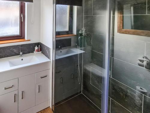 a bathroom with a shower and a sink at Coiltie Cottage in Drumnadrochit