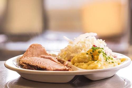 a plate of food with meat and rice on a table at Gasthof Pichler in Grimmenstein