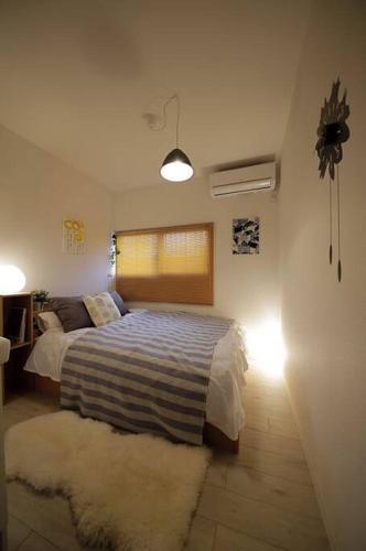 a bedroom with a bed with a window and a rug at Osaka Glitter 3 floor whole house 6-10 ppl 5mins walk to station in Osaka
