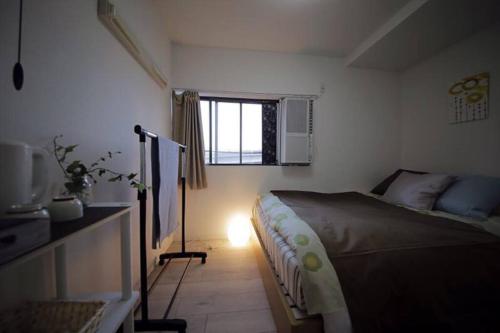 a small bedroom with a bed and a window at Osaka Glitter 3 floor whole house 6-10 ppl 5mins walk to station in Osaka
