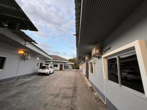 a car parked in a parking lot between two buildings at Metro Palace in Satun