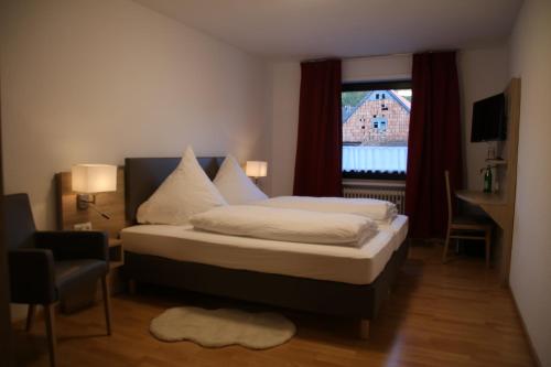 a bedroom with a bed and a window at Gasthaus Reinhardt in Alfeld