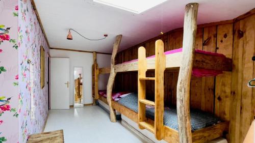 セニョスにあるCarwyns Surf Houseの木製の壁の客室で、二段ベッド2組が備わります。