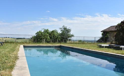 a swimming pool in a yard with a fence at Maison ou chambres dans une belle ferme lauragaise 