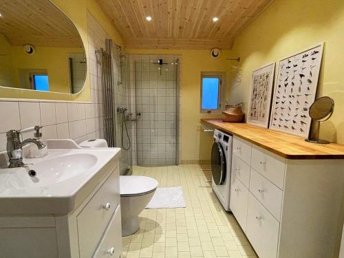 a bathroom with a sink and a washing machine at Holiday home Löderup V in Löderup