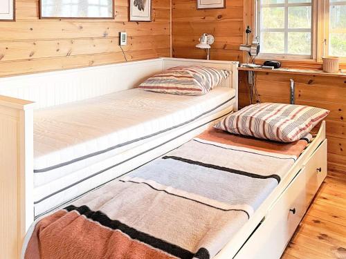 two beds in a room with wooden walls at Holiday home SEXDREGA in Sexdrega
