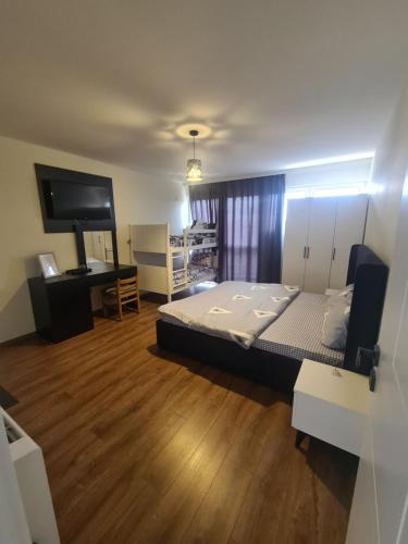 Dormitorio con cama, escritorio y TV en Hotel Frida, en Gjakove