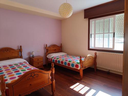 a bedroom with two beds and a window at Faro de Aldan in Aldán
