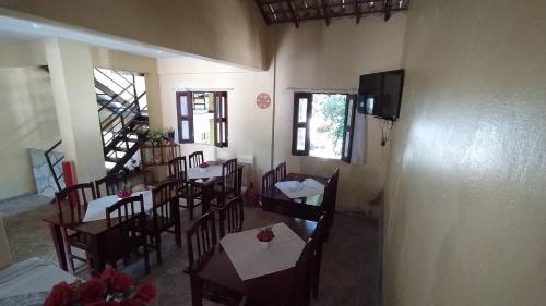 a restaurant with tables and chairs in a room at Pousada Flamboyan in Rio de Contas