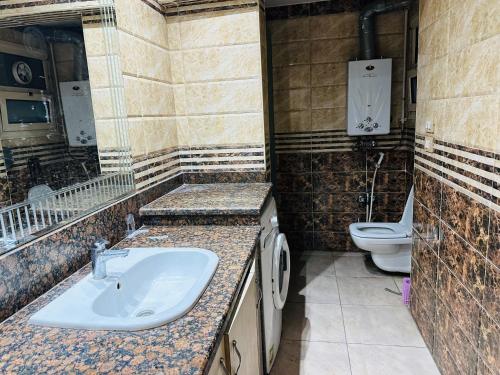 a bathroom with a sink and a toilet at 100برج الثورة الدور 2 in Cairo