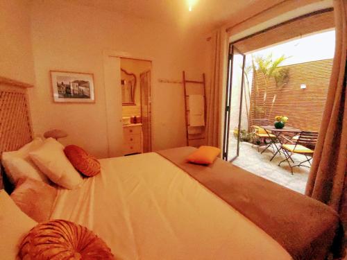 a bedroom with a large bed and a balcony at Romantic patio-house for 2 in the old centre in La Orotava