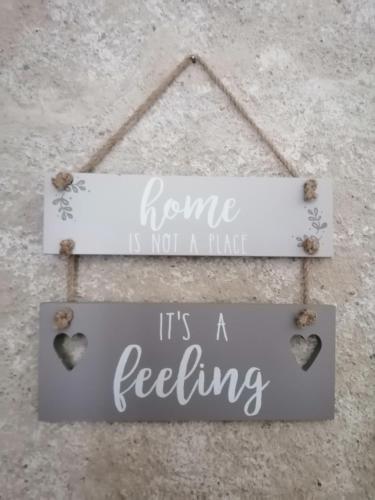 a sign that says home is not a hate its a feeling at Paradise Grand Jardin et Terrasse 2 chambres in Férolles
