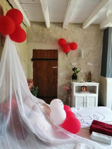 a bedroom with red and white balloons on a bed at Paradise Grand Jardin et Terrasse 2 chambres in Férolles