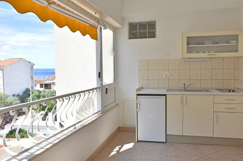 a kitchen with a balcony with a sink and a window at Apartments Stone Tučepi in Tučepi