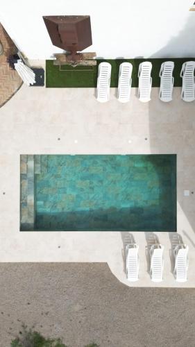 a group of white chairs and a swimming pool at Lidias Rural House HUTB0615 in Barcelona