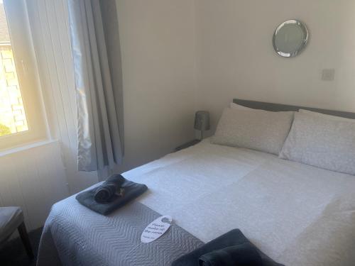 a bedroom with a bed with a hat on it at Dunarle Guesthouse in Oban