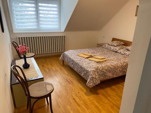 um quarto com 2 camas, uma mesa e uma janela em Friends Villa Apartments 2 em Hévíz