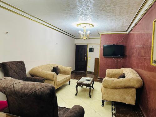 uma sala de estar com dois sofás e uma televisão em 84 شارع الجليل جسر السويس no Cairo