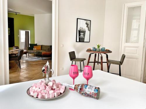 une table avec deux verres roses et une assiette de bonbons dans l'établissement Loft2Be, Vienna City Loft for 8, à Vienne