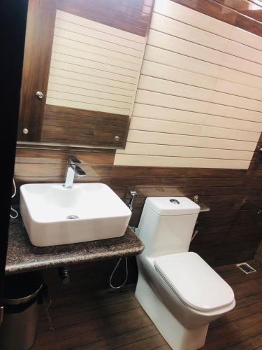 a bathroom with a white sink and a toilet at Belair Resorts in Kotagiri