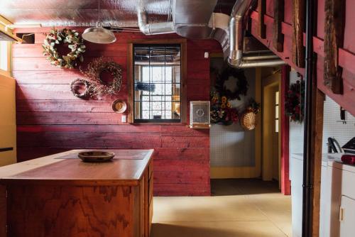 cocina con pared roja y encimera de madera en Hummingbird House by Country House Escapes en Pine Hill