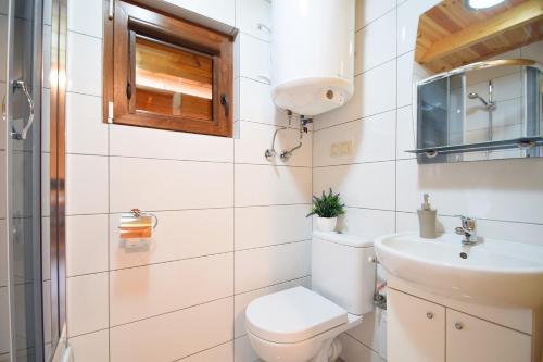 a bathroom with a toilet and a sink at Houses with a garden- Domki z ogródkiem Radison domki in Mielno