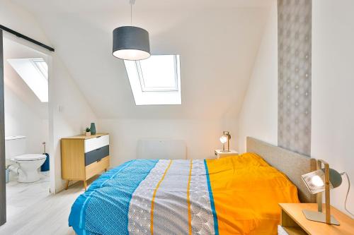 ein Schlafzimmer mit einem Bett mit einer gelben und blauen Decke in der Unterkunft Little Cosy - T2 avec parking in Vierzon