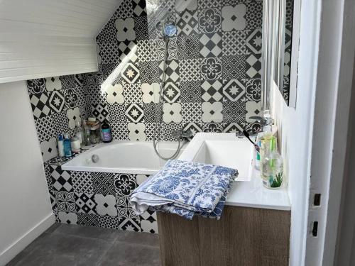 a bathroom with a white sink and a black and white tiles at Villa d'architecte in La Celle-Saint-Cloud