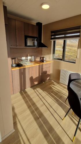 a small kitchen with a table and a window at Black Beach Farm in Vík