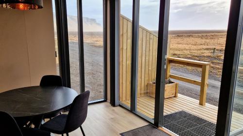 a room with a table and a view of the desert at Black Beach Farm in Vík