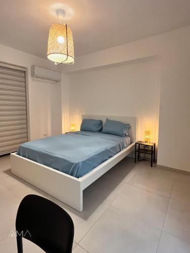 um quarto com uma cama com lençóis azuis e um candeeiro em Hermoso refugio céntrico em Santo Domingo