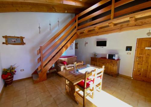 ein Wohnzimmer mit einem Holztisch und einer Treppe in der Unterkunft Fleurs De Neige in Pila