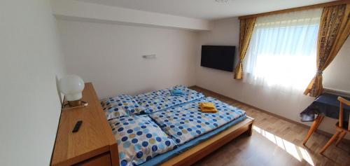 a bedroom with a bed with a blue comforter and a window at Stoffenhof in Oberdrauburg