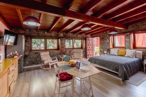 1 dormitorio con 1 cama y 1 mesa en Papaya Cottage Punta del Hidalgo, en Punta del Hidalgo