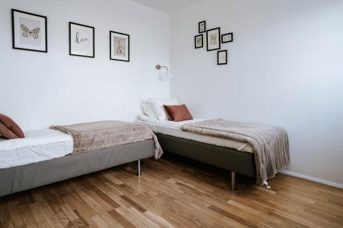 1 dormitorio con 2 camas y suelo de madera en Ocean Views and Gorgeous Design in a Light-Filled 3 BDRM/1.5 Bath Village Home, en Stokkseyri