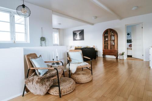 - un salon avec deux chaises et une table dans l'établissement Ocean Views and Gorgeous Design in a Light-Filled 3 BDRM/1.5 Bath Village Home, à Stokkseyri