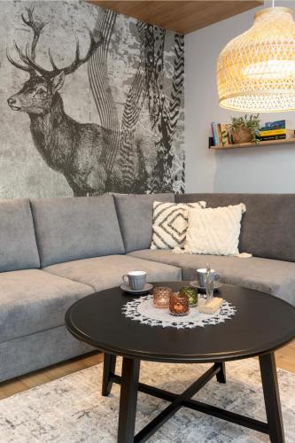 a living room with a couch and a table with food on it at REST4U APARTAMENTY z SAUNAMI in Szczyrk