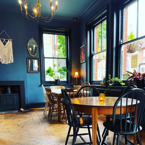 a dining room with a wooden table and chairs at Rooms At The Rosebery in Norwich