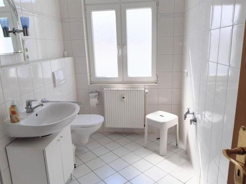 a white bathroom with a sink and a toilet at Helle, offene Whg im Zentrum vom Ostseebad Göhren in Göhren