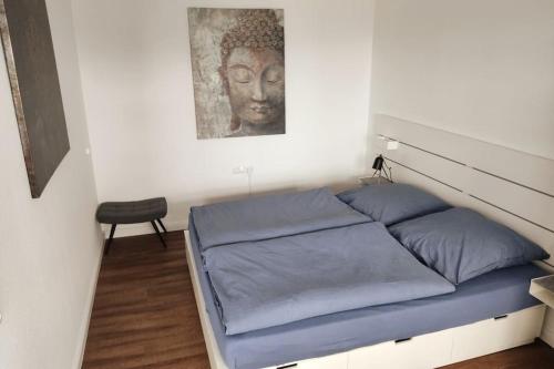 a bed in a room with a picture of a head at Helle, offene Whg im Zentrum vom Ostseebad Göhren in Göhren