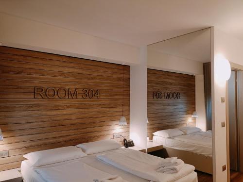 a hotel room with two beds and a mirror at B612 in Levico Terme