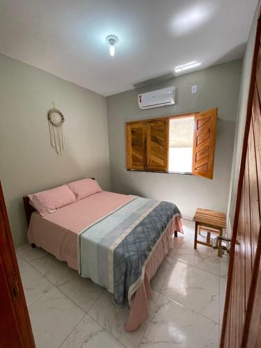a bedroom with a bed and a window at Casa de Praia do Luiz in Luis Correia