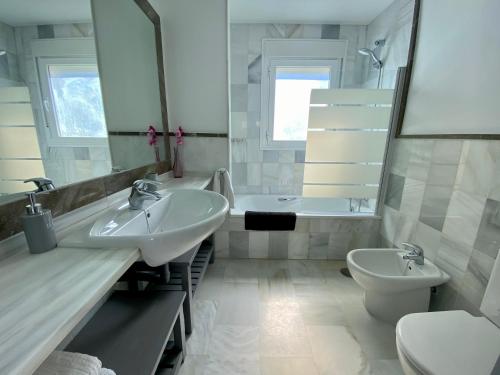 ein Badezimmer mit zwei Waschbecken, einer Badewanne und einem WC in der Unterkunft CASA PARAISO DEL SUR - Gran casa independiente de Lujo con amplias terrazas in Costa Ballena