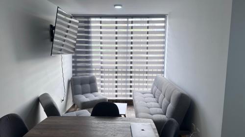 a dining room with a table and chairs and a large window at 026 Hills in Dosquebradas