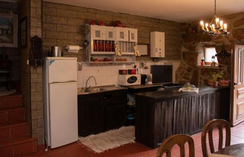 a kitchen with a white refrigerator and a sink at Casa Senhor da Ponte in Mondim de Basto