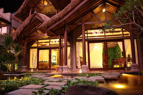 a house with large glass windows and a patio at Avalon Ubud Castle & SPA in Ubud