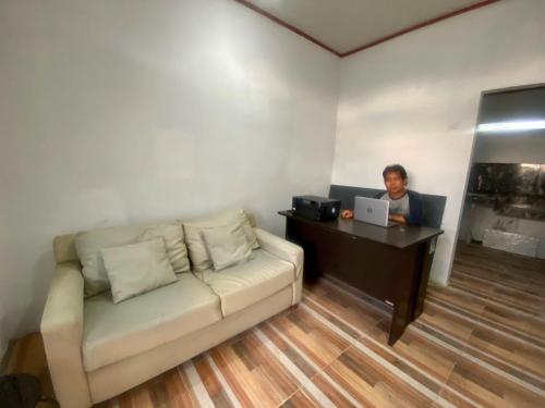 a woman sitting at a desk with a laptop at EXPRESS O 92147 Nia Residence in Depok