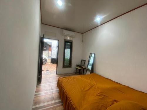 a bedroom with a bed with an orange sheet at EXPRESS O 92147 Nia Residence in Depok