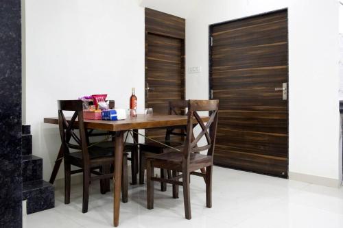 een eetkamer met een houten tafel en stoelen bij Lovely - 4 bedroom VILLA in Jodhpur